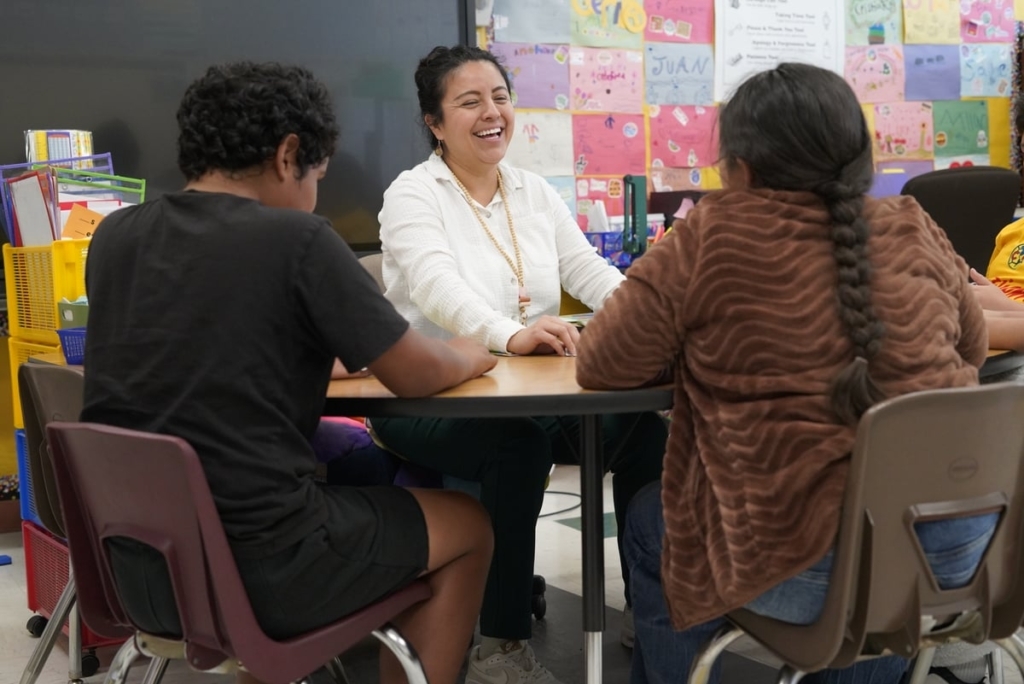 Alma Perez Hernandez Laughs As She Sits At A Table With Some Students