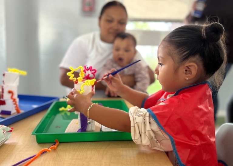 Niña pintando un juguete en un evento