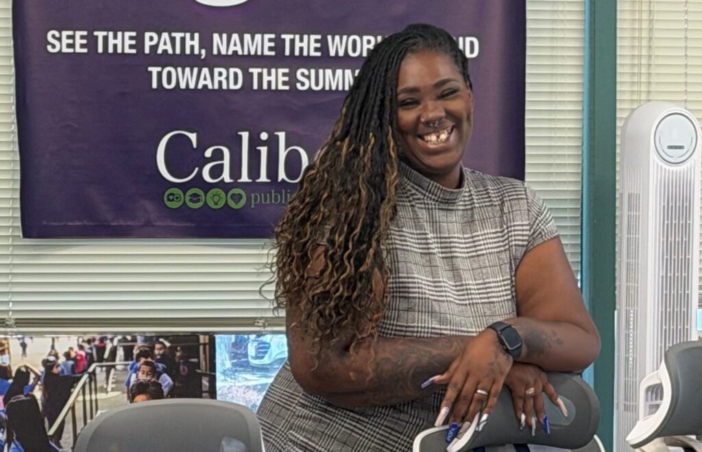 Lashunda Cain smiles as she leans on a chair