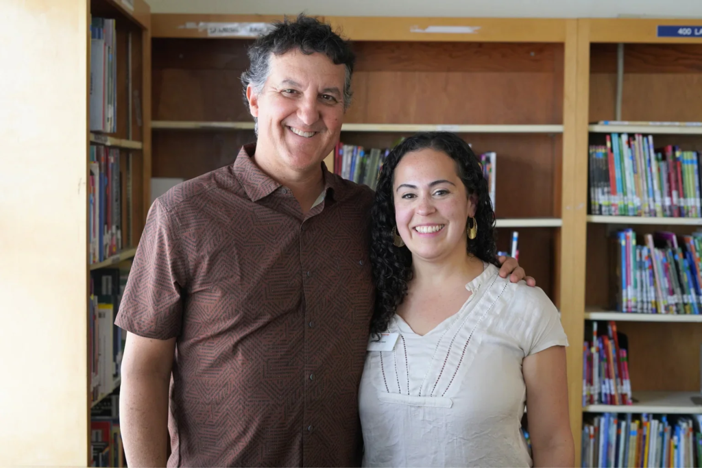 WCCUSD Math Coordinator Mark Lobaco poses for a photo standing next to Instruction Partners coach Becca Varon