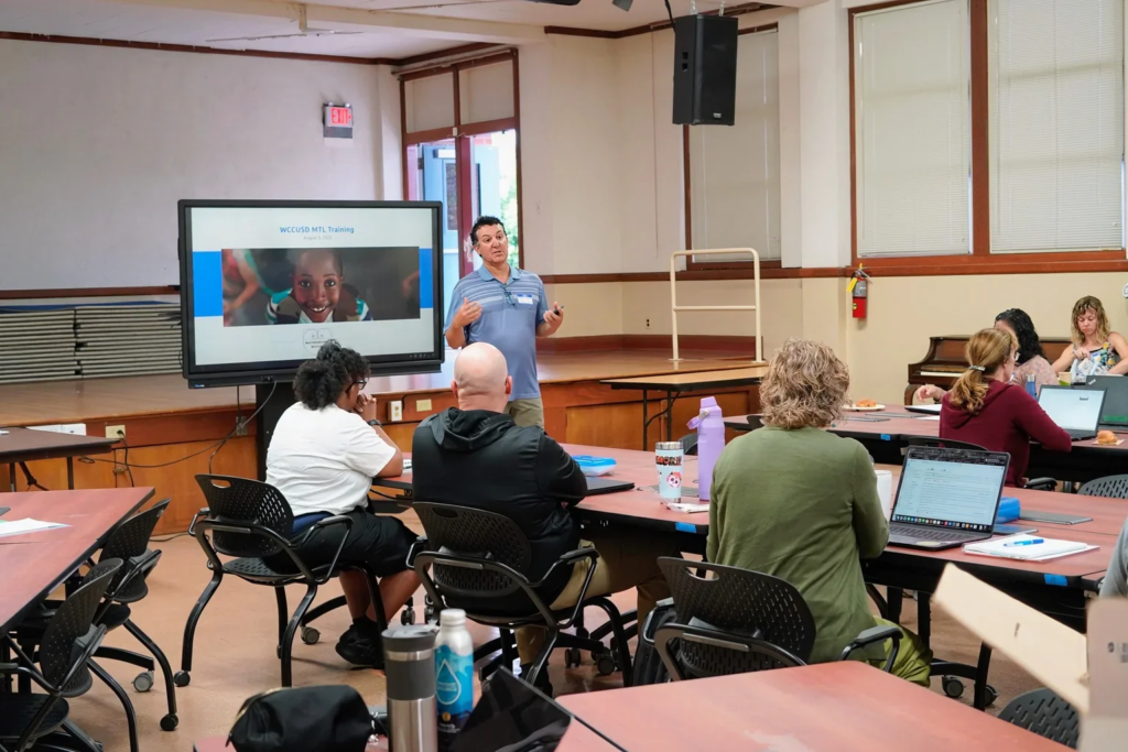 WCCUSD Math Coordinator Mark Lobaco leads a presentation as he stands in front of a group of Math Teacher Leaders.