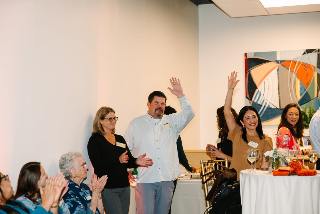 Rob Kirker and Katherine Acosta-Verprauskus wave